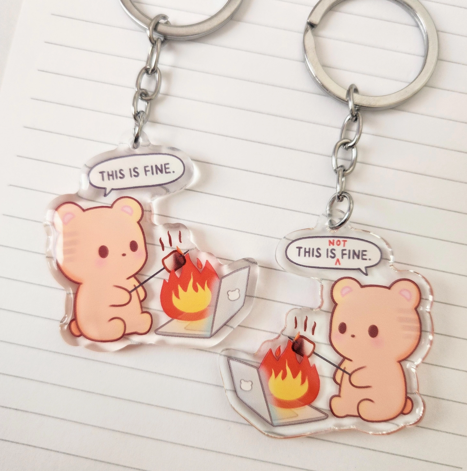 This double-sided keychain features an innocent round brown bear toasting marshmallows over its burning laptop. The front side says, "This is fine," while the back says, "This is not fine," perfectly capturing those chaotic moments we all know too well. Kawaii