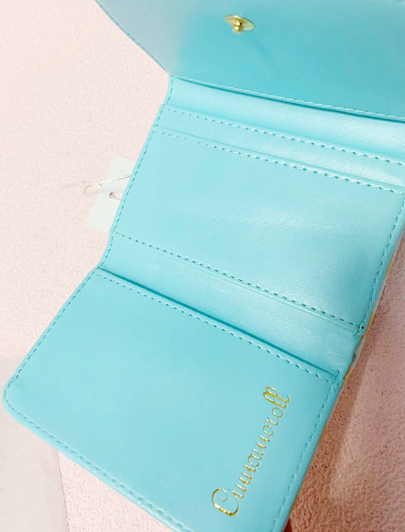 Add a touch of adorable charm to your daily essentials with this Cinnamoroll Face Baby Blue Diamond Print Wallet! Perfect for fans of the beloved Sanrio character, Cinnamoroll, this wallet is as functional as it is cute.

Featuring Cinnamoroll in a classy but fun baby blue diamond design, the wallet is accented with a stylish gold clasp, giving it a chic, feminine look.

Made from durable synthetic leather, with multiple compartments for cards, cash, and coins.