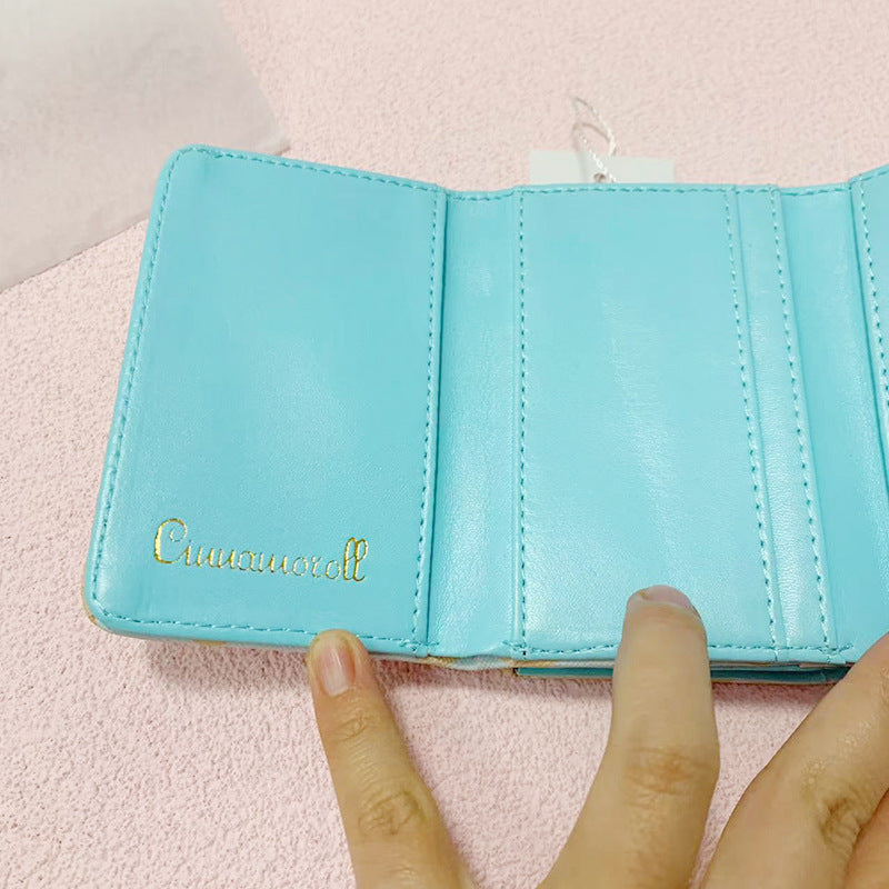 Add a touch of adorable charm to your daily essentials with this Cinnamoroll Face Baby Blue Diamond Print Wallet! Perfect for fans of the beloved Sanrio character, Cinnamoroll, this wallet is as functional as it is cute.

Featuring Cinnamoroll in a classy but fun baby blue diamond design, the wallet is accented with a stylish gold clasp, giving it a chic, feminine look.

Made from durable synthetic leather, with multiple compartments for cards, cash, and coins.