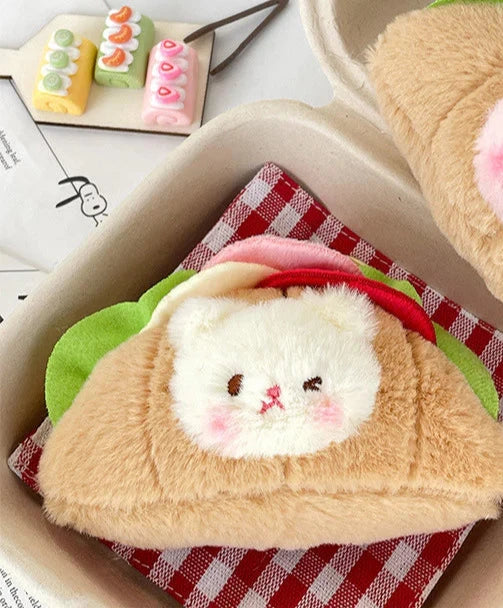 This little guy adds a dose of cute to your everyday carry with the Croissant Sandwich Bear Plush Keychain! This irresistibly cute accessory features a tiny, soft bear atop a buttery croissant sandwich, with all the fixin's. Perfect for fans of food-inspired designs, sandwich lovers, and all things bear-y-licious, this keychain brings all the kawaii charm.