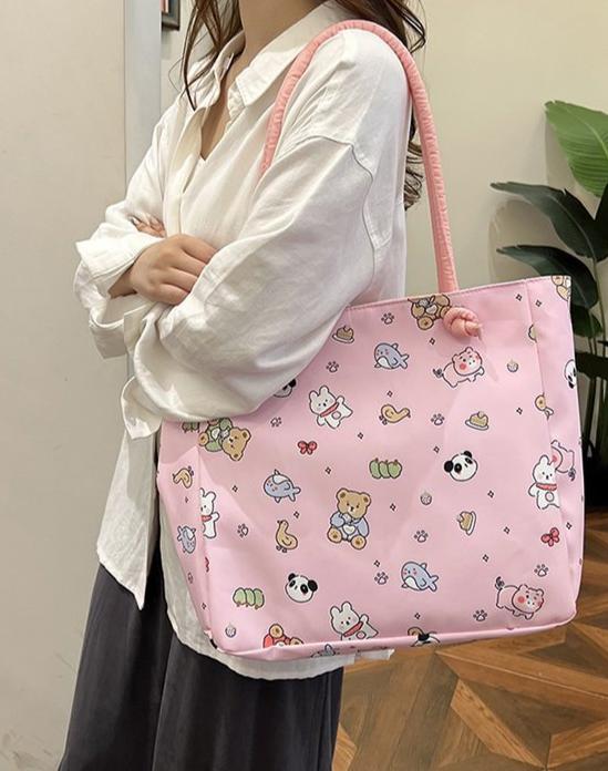 Fun, cute, and functional, this Everything Kawaii Print Shoulder Bag is a delightful bag featuring an enchanting all-over print. Showcasing adorable characters and designs: a playful panda, a cheerful bunny holding a carrot, a cuddly teddy bear, a narwhal with a magical horn, an all sorts of other whimsically happy delights!

This bag is perfect for school, work, or casual outings and is made from durable, nylon fabric with a soft pastel finish. It’s both stylish and practical with the double shoulder strap