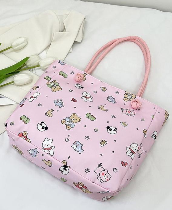 Fun, cute, and functional, this Everything Kawaii Print Shoulder Bag is a delightful bag featuring an enchanting all-over print. Showcasing adorable characters and designs: a playful panda, a cheerful bunny holding a carrot, a cuddly teddy bear, a narwhal with a magical horn, an all sorts of other whimsically happy delights!

This bag is perfect for school, work, or casual outings and is made from durable, nylon fabric with a soft pastel finish. It’s both stylish and practical with the double shoulder strap