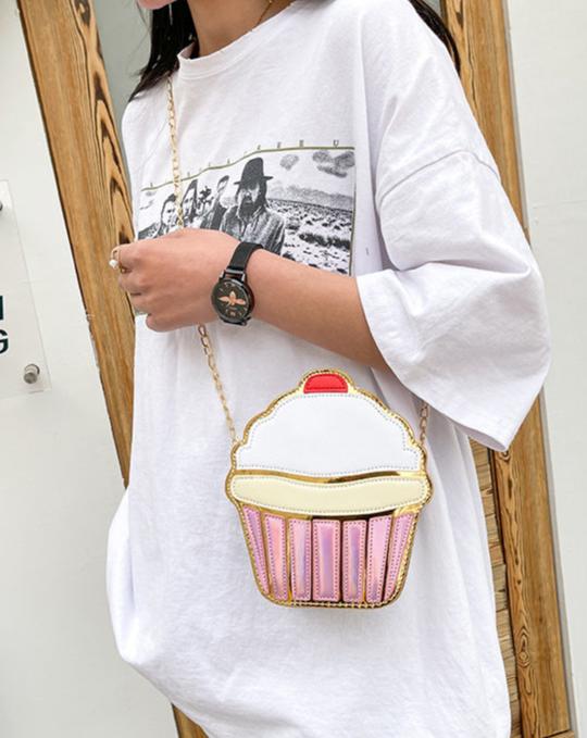 This delightful accessory is perfect for adding a playful yet chic touch to your outfit. Designed to resemble a frosted cupcake with shimmering gold detail, it’s a statement piece for anyone who loves kawaii style with a dash of glamour.

The Frosted Cupcake Gold Kawaii Street Style Purse features a rounded cupcake shape, complete with a fluffy pastel "frosting" top, a red cherry topping, and a metallic gold base that gleams in the light.