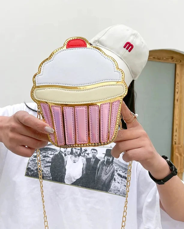 This delightful accessory is perfect for adding a playful yet chic touch to your outfit. Designed to resemble a frosted cupcake with shimmering gold detail, it’s a statement piece for anyone who loves kawaii style with a dash of glamour.

The Frosted Cupcake Gold Kawaii Street Style Purse features a rounded cupcake shape, complete with a fluffy pastel "frosting" top, a red cherry topping, and a metallic gold base that gleams in the light.