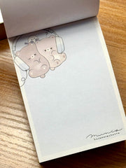 This charming kawaii notepad showcases buddies doing what buddies do-- sharing their favorite stuffs, especially music via headphones! This is a cute pick me up gift for yourself or another music afficionado. Everyone's needing to keep notes, grand or small, and why not color your day with a sweet design to do so?

This delightful piece will add a touch of musical fun to your stationery collection, making every note feel special.
