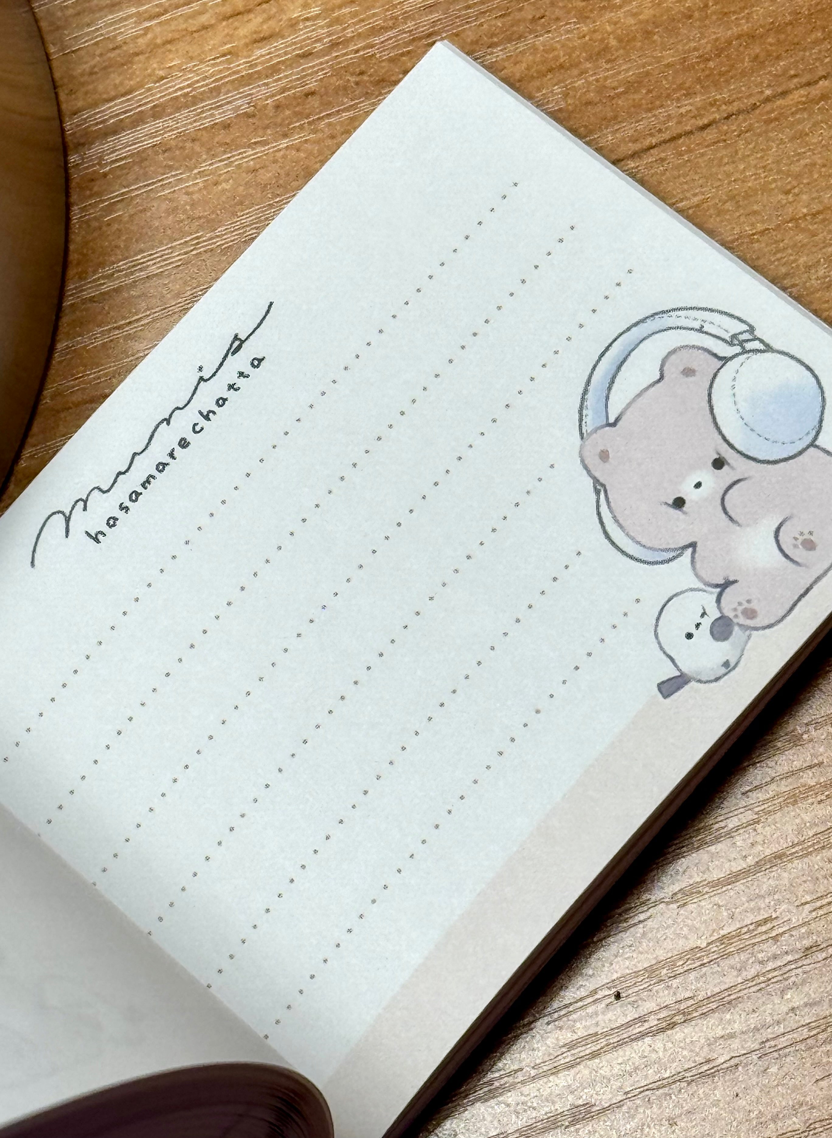 This charming kawaii notepad showcases buddies doing what buddies do-- sharing their favorite stuffs, especially music via headphones! This is a cute pick me up gift for yourself or another music afficionado. Everyone's needing to keep notes, grand or small, and why not color your day with a sweet design to do so?

This delightful piece will add a touch of musical fun to your stationery collection, making every note feel special.