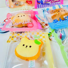 Say hello to the cutest little snack to carry your essentials! This unique Kuma Bakery Bear in a Bag Keychain, French Toast features a soft, squishy bread bear plushie tucked inside a charming clear and yellow checkered themed mini wallet. The softness is like a mochi dessert and the design is unmatched.