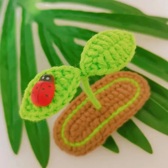 Show off your growing little sprout with this Lil' Sprout Handmade Crocheted Hair Clip! An absolutely adorable accessory for littles and fun loving young-at-hearts, this cotton crocheted clip secures at the very top of the head to give the most heart warming crush to everyone who lays eyes on it- two little green sprouts peep out over a garden bed of dirt.