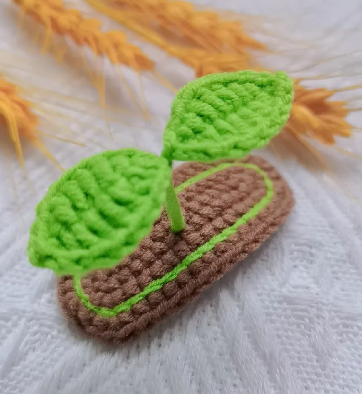 Show off your growing little sprout with this Lil' Sprout Handmade Crocheted Hair Clip! An absolutely adorable accessory for littles and fun loving young-at-hearts, this cotton crocheted clip secures at the very top of the head to give the most heart warming crush to everyone who lays eyes on it- two little green sprouts peep out over a garden bed of dirt.