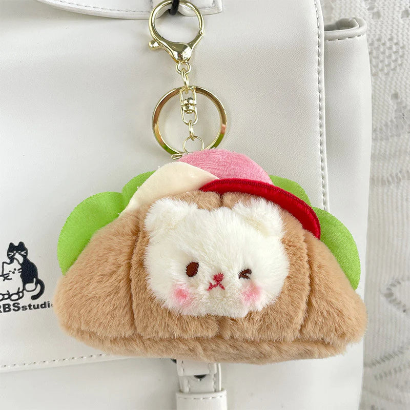 This little guy adds a dose of cute to your everyday carry with the Croissant Sandwich Bear Plush Keychain! This irresistibly cute accessory features a tiny, soft bear atop a buttery croissant sandwich, with all the fixin's. Perfect for fans of food-inspired designs, sandwich lovers, and all things bear-y-licious, this keychain brings all the kawaii charm.