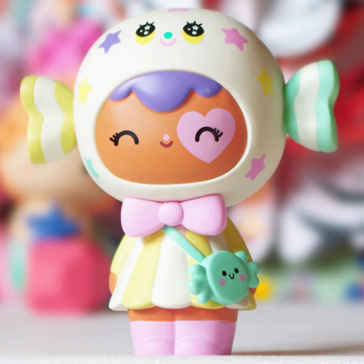 The Candy Button Vinyl Figurine Doll by Momiji has a removable base that reveals a secret wishing paper. Write your wish and let her take care of it. Good things are coming!  Momiji is a Japanese sensation, especially among collectors, and it’s easy to see why. This vinyl figurine, colorful and kind, brings much encouragement to anyone glancing in her direction. Each Momiji doll is made with a secret compartment for holding special messages within.