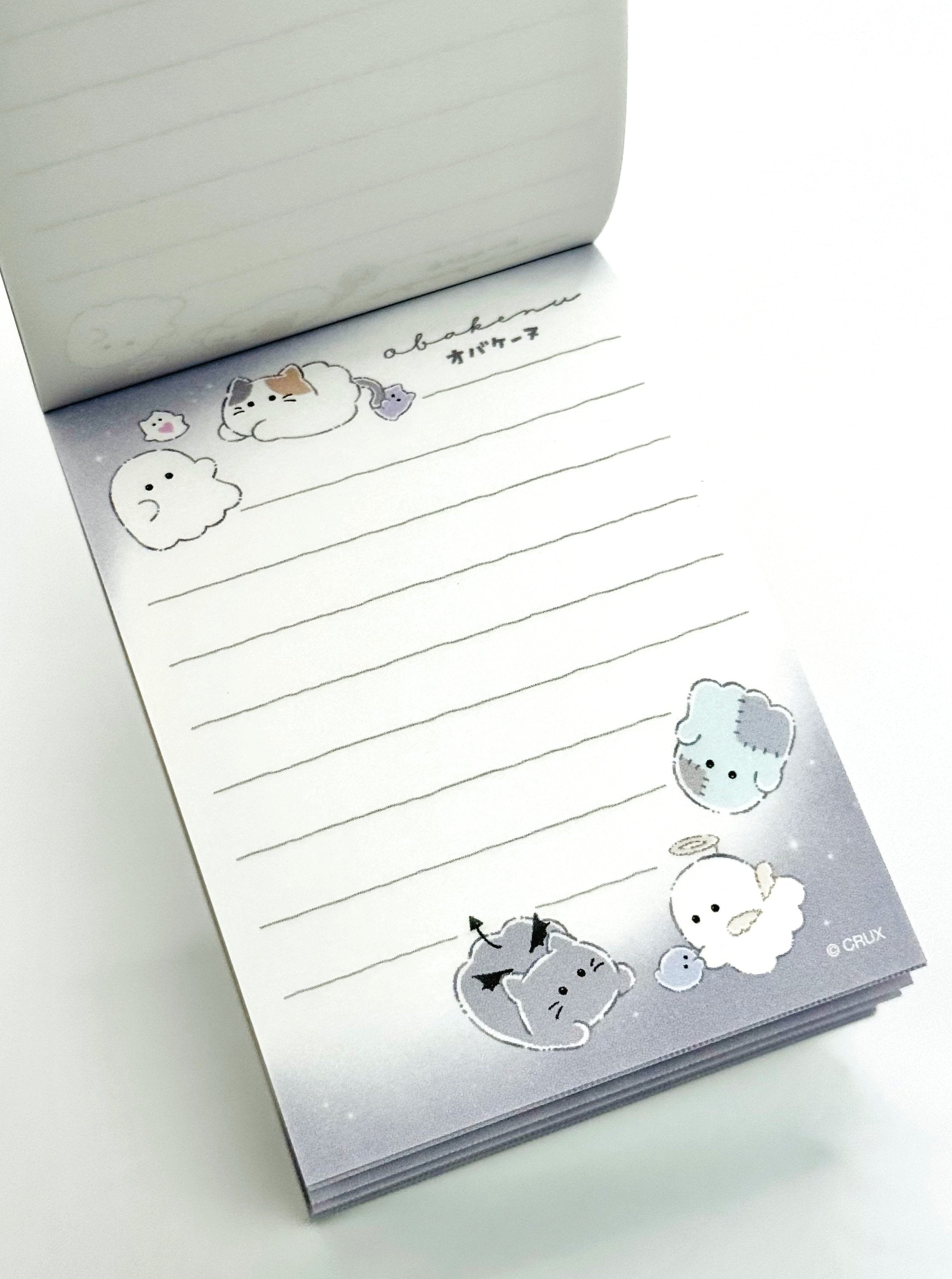 Obakane Ghost Stationary Set feature two notebooks with two different designs, printed in full color. Quality and chic holographic binding, yet easy tear-out sheets. A stand-up pencil sharpener featuring ghosts, cats, and dogs completes the set.