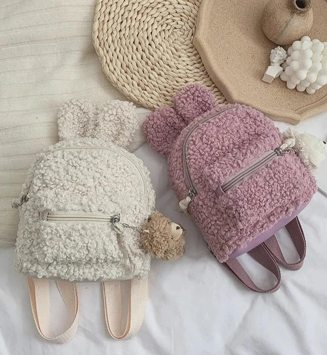 Our Mini Bunny Backpacks in Teddy Plush bring cozy cuteness to your everyday adventures. These adorable mini backpacks are made from super-soft teddy plush material, making them as huggable as they are functional. Each backpack is in the shape of a charming bunny head with pointed ears, giving it a playful look that’s perfect for adding a bit of Kawaii flair to your outfit.