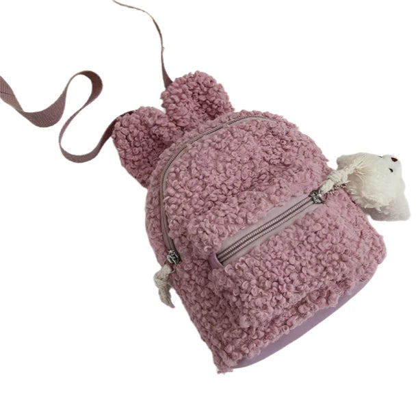 Our Mini Bunny Backpacks in Teddy Plush bring cozy cuteness to your everyday adventures. These adorable mini backpacks are made from super-soft teddy plush material, making them as huggable as they are functional. Each backpack is in the shape of a charming bunny head with pointed ears, giving it a playful look that’s perfect for adding a bit of Kawaii flair to your outfit.