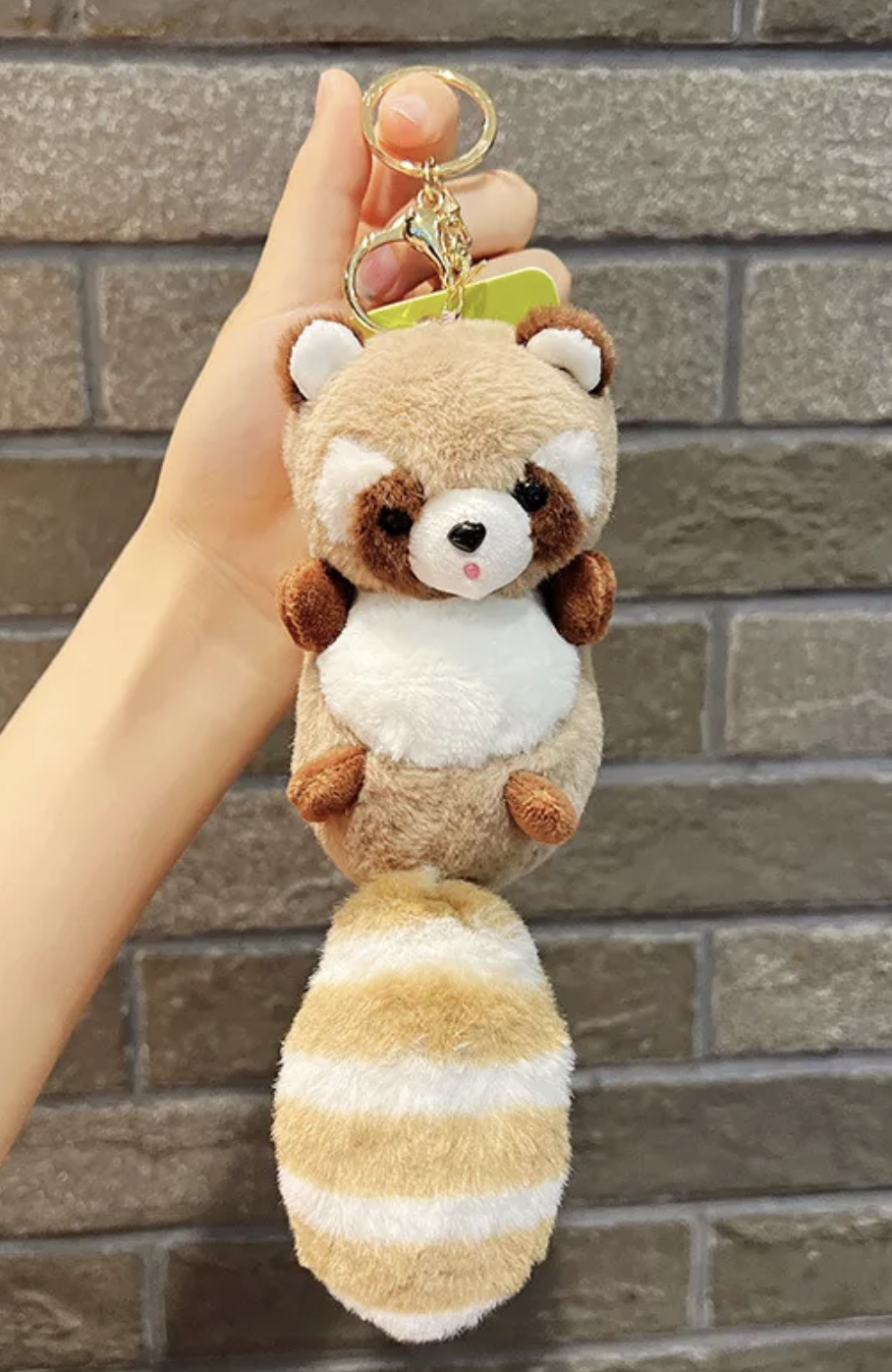 Discover charm and cuddliness with our adorable raccoon plushie keychain. Featuring a delightful pink hue and a light brown striped tail, this compact companion adds whimsy to your keys or backpack. Crafted with soft, high-quality materials, it's perfect for both kids and adults. Shop now and bring a touch of woodland magic wherever you go!