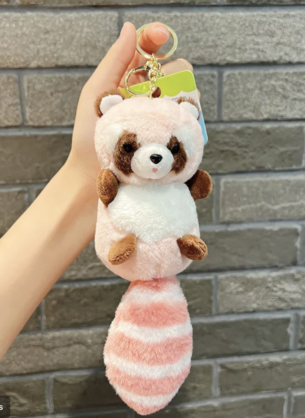 Discover charm and cuddliness with our adorable raccoon plushie keychain. Featuring a delightful pink hue and a light brown striped tail, this compact companion adds whimsy to your keys or backpack. Crafted with soft, high-quality materials, it's perfect for both kids and adults. Shop now and bring a touch of woodland magic wherever you go!