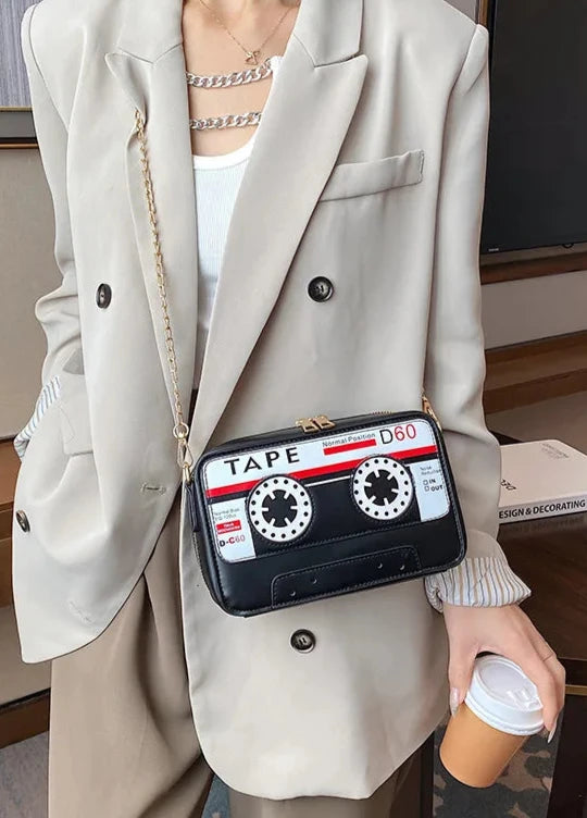 Take your style back in time with but with a fresh kawaii take with our Retro Cassette Tape Kawaii Street Style Black Shoulder Bag. This classy but funky, nostalgic accessory brings the charm of the '80s and '90s into modern-day fashion, combining a fun cassette tape design with streetwear vibes. It's styled to look like a classic cassette tape, complete with vibrant colors, fun graphics, and playful text, making it a perfect tribute to vintage music culture.