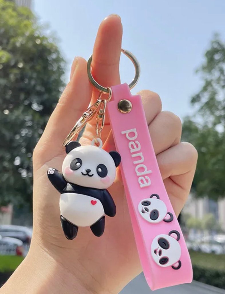 These happy pandas are having an extroverted day! Choose from the neighborly waving panda with a little heart on its chest, or the joy-scrolling panda about to take its best selfie of the day. The Social Panda Friend Keychain includes a gold metal keyring and durable pink rubber strap to keep your panda friend (and your keys) secure.