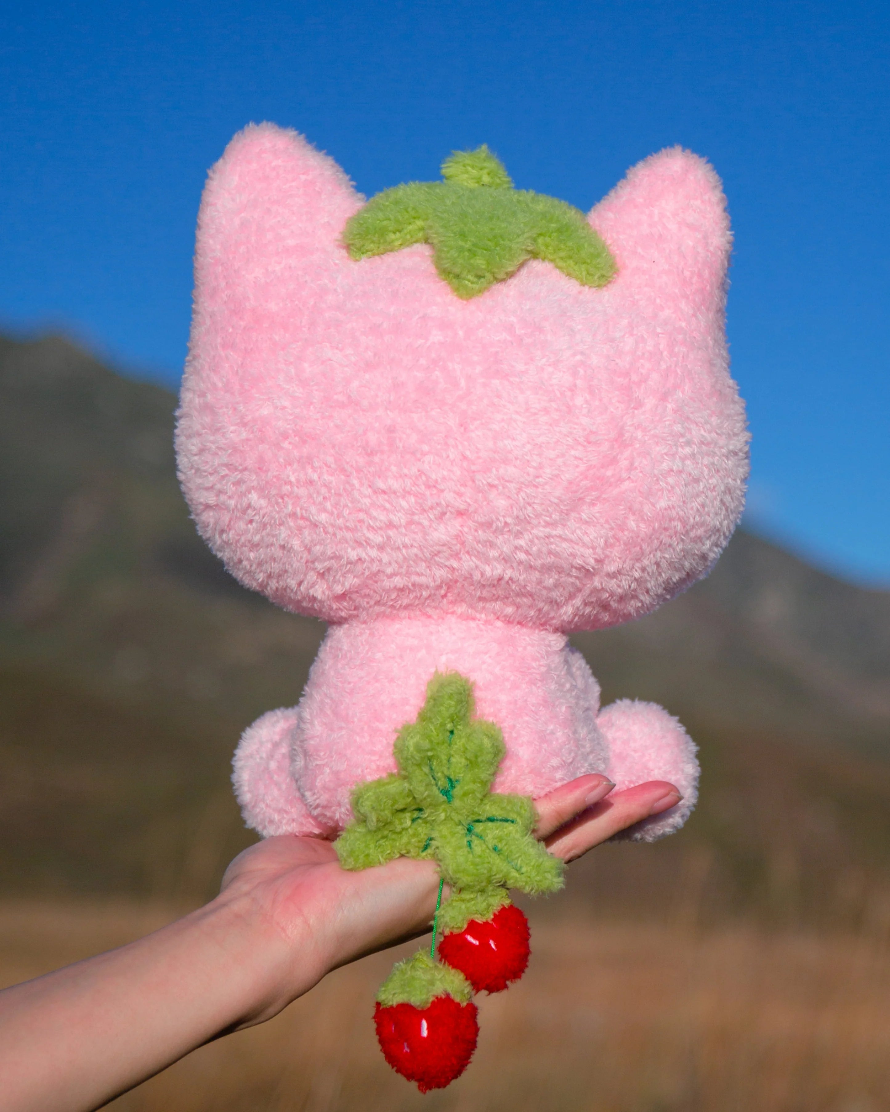 Soft, silly, and full of love, Strawmi is boutique designer MikouArt's sweetest design! Strawmi’s iconic strawberry head and tail are made with custom materials and sewing techniques. Two tiny, movable strawberries on the tail add some extra playful charm. Strawberries are the essential kawaii fruit for good reason- Strawmi makes the perfect unique gift for fans and collectors of all things strawberry-themed!