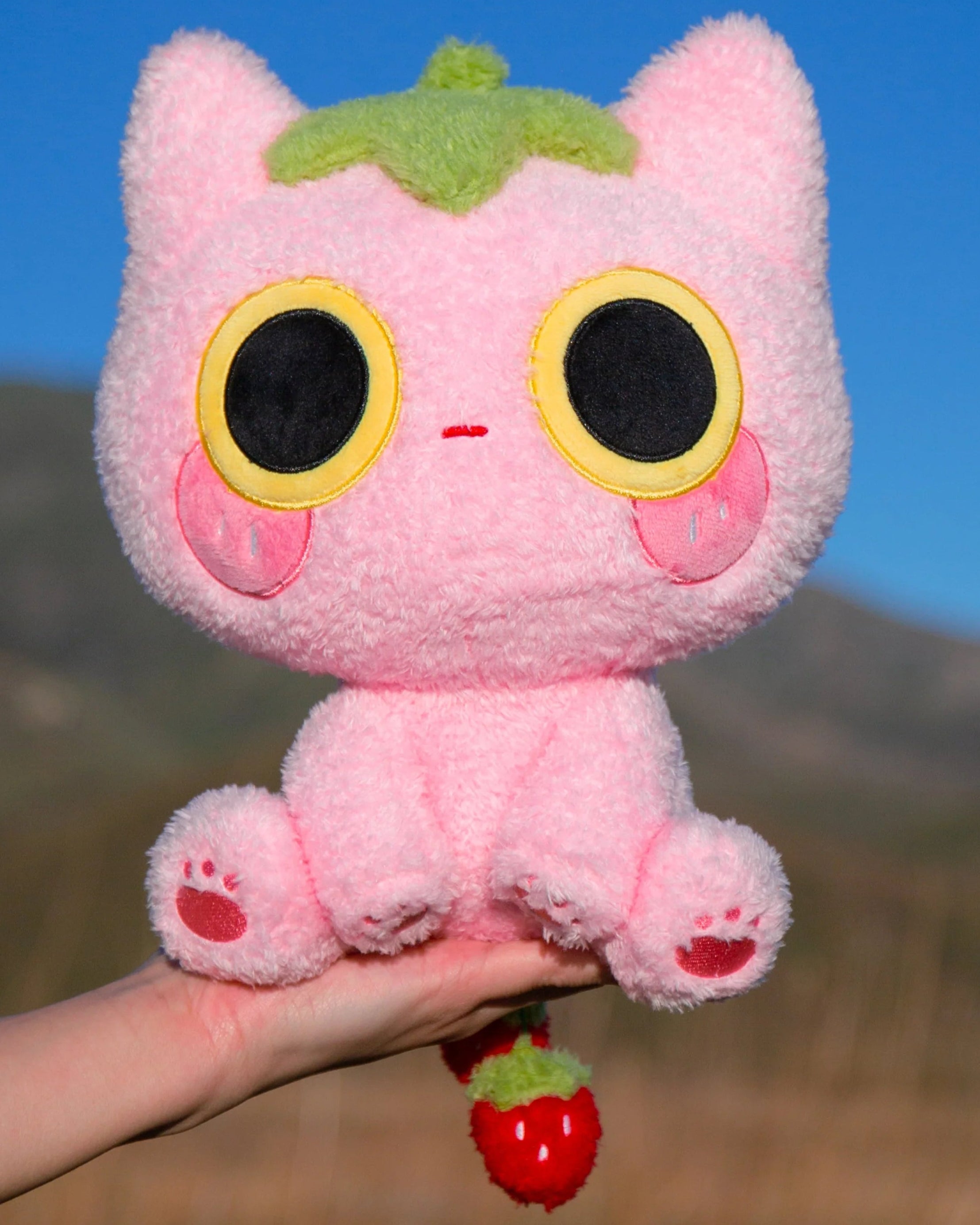 Soft, silly, and full of love, Strawmi is boutique designer MikouArt's sweetest design! Strawmi’s iconic strawberry head and tail are made with custom materials and sewing techniques. Two tiny, movable strawberries on the tail add some extra playful charm. Strawberries are the essential kawaii fruit for good reason- Strawmi makes the perfect unique gift for fans and collectors of all things strawberry-themed!