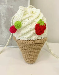 Sweeten up your style with the Vanilla Soft Serve Crocheted Crossbody Bag. This charming, handmade bag is a must-have for those who love unique accessories and kawaii cuteness. Crafted with care, it features a soft serve ice cream design in creamy vanilla crochet, with delightful crocheted strawberry and cherries on the drawstring closure. Whether you're out for a fun day with friends or just looking to add a touch of sweetness to your outfit, this bag is sure to turn heads.